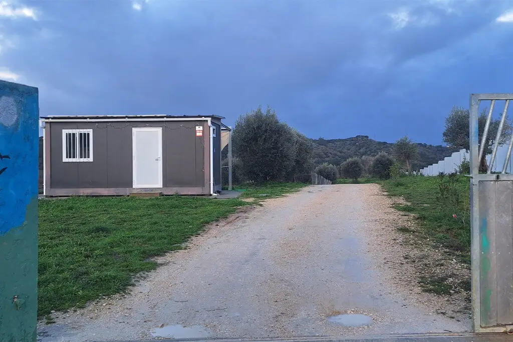 Entrada de espaço exterior com caminho em terra e edifício